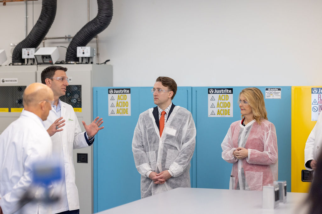 Phlow Corporation Two men and two women talking inside of the Phlow lab